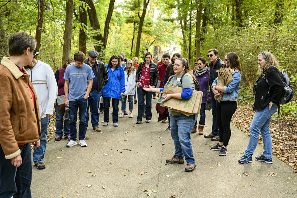 Photo: Woman speaking to small group of people surrounding her on a trail