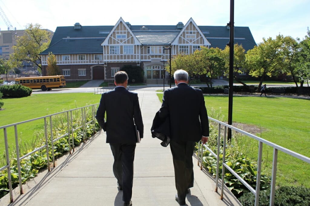 Photo: Green and unidentified man seen from behind walking toward Stock Pavilion