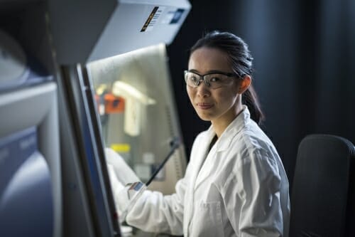 Photo: Gao in lab with hand holding experiment