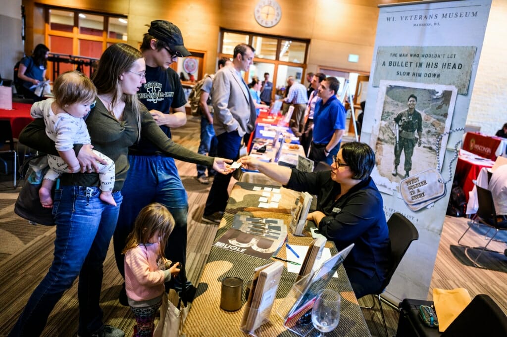 Photo: Family members talk with a person behind a table.