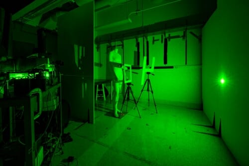 Photo: Darkened room with green laser light projected on wall