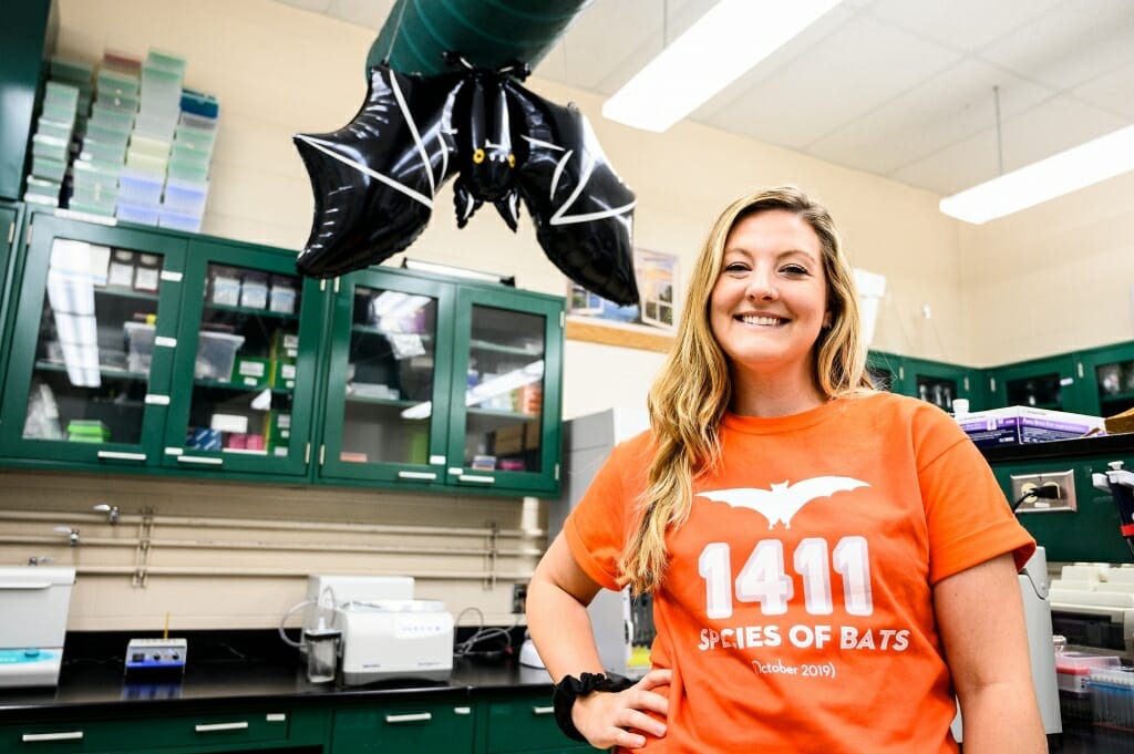 Photo: Wray standing under an inflatable bat hanging from the ceiling