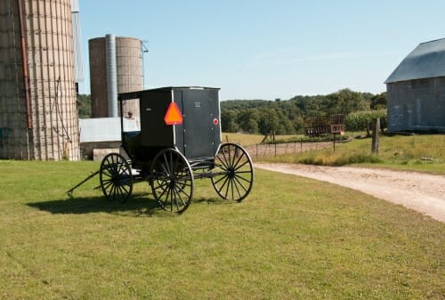 Photo: A wagon stands in a farm yard.