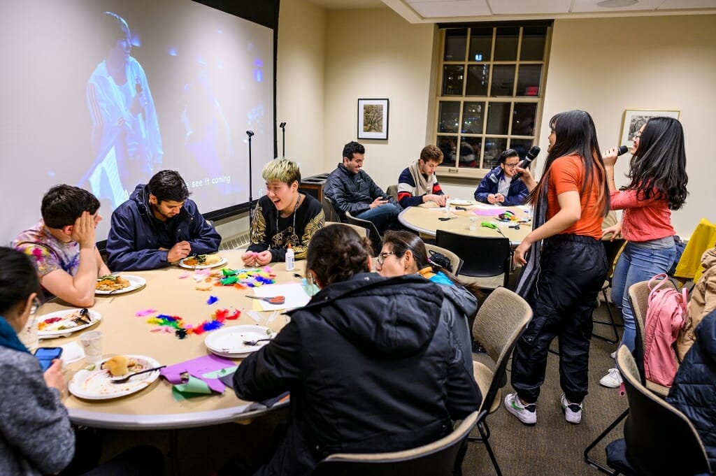 Photo: From left to right, Daniel Lassman, Ankur Agrawal and Skyler Byun chat while Emily Bian and Huong Nguyen sing karaoke.