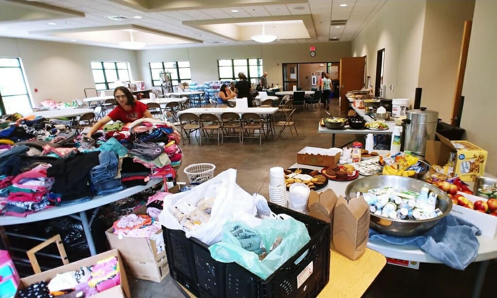 Photo: A big room is filled with supplies and people.