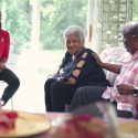 Photo: Alex Gee sitting in living room with mother Verline and daughter Lexi