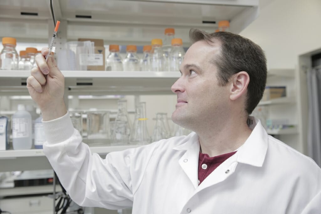 Photo: Kip Ludwig looking at a syringe