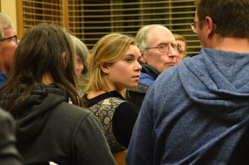 Photo: A woman listens as part of an audience.