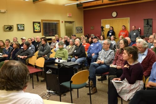 Photo: A meeting room full of people listening to a speaker.