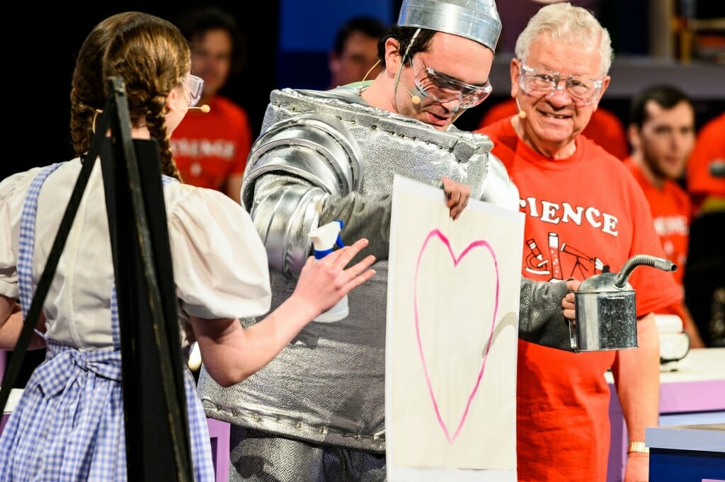 Photo of the Tin Man holding a piece of paper with a pink heart.