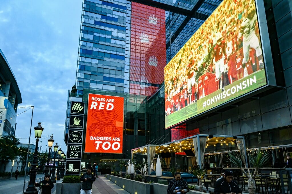 Photo: Large lighted billboards with pictures and titles of UW football