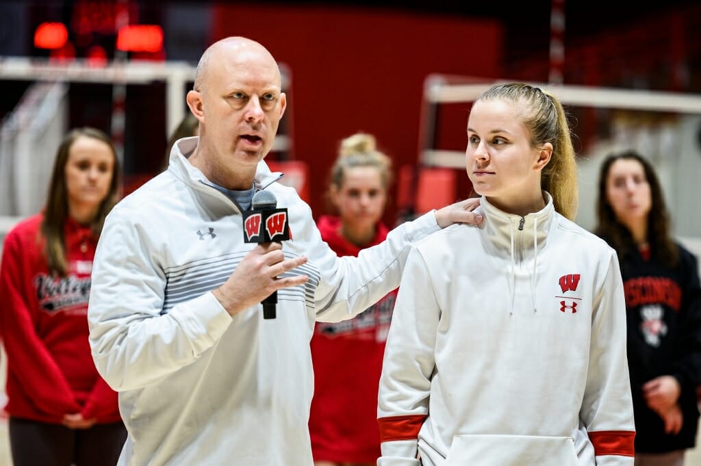 Photo: A coach holding a microphone stands with a player.