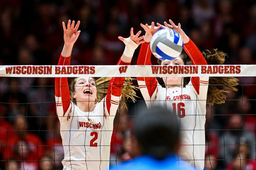 Photo: Wisconsin setter Sydney Hilley (2) and middle blocker Dana Rettke (16) block the ball at the net line.