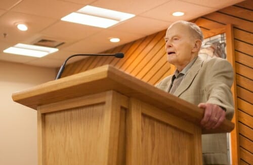 Photo: M. Crawford Young speaking into a microphone at a podium