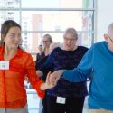 Photo: Student and older adult holding hands in a ballroom dance step