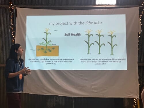 Photo: Daniel Hayden standing next to a poster about soils and white corn