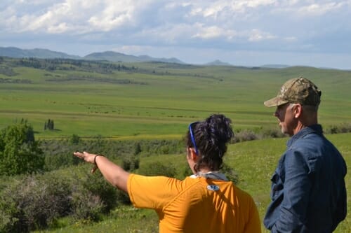 Two people talk in an open field.