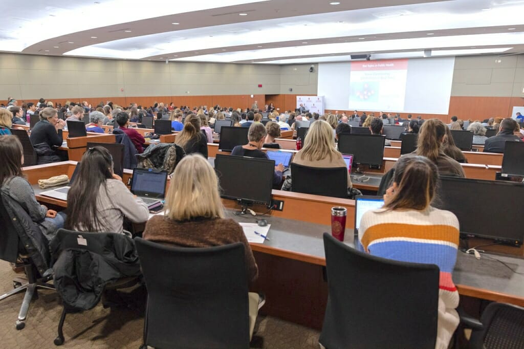 Photo: Audience seated in rows as seen from back of room