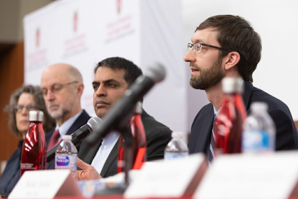 Photo: Closeup of Bateman speaking at head table, flanked by other panelists