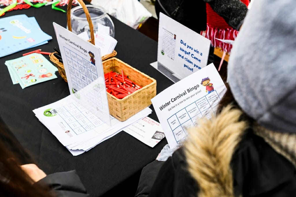 A group sits around a table with bingo cards.