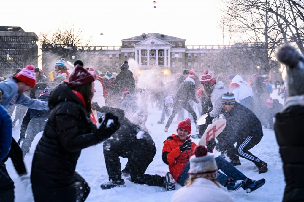 People throwing snow in front of Bascom Hall, some falling to the ground