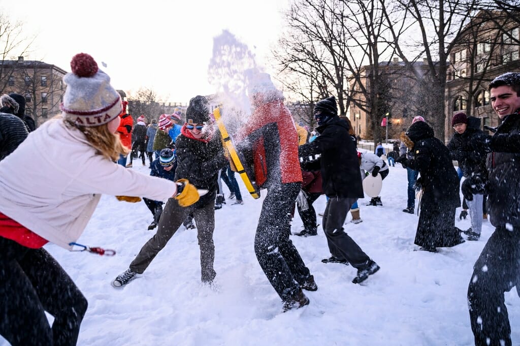 2 people throwing snow at each other at close range