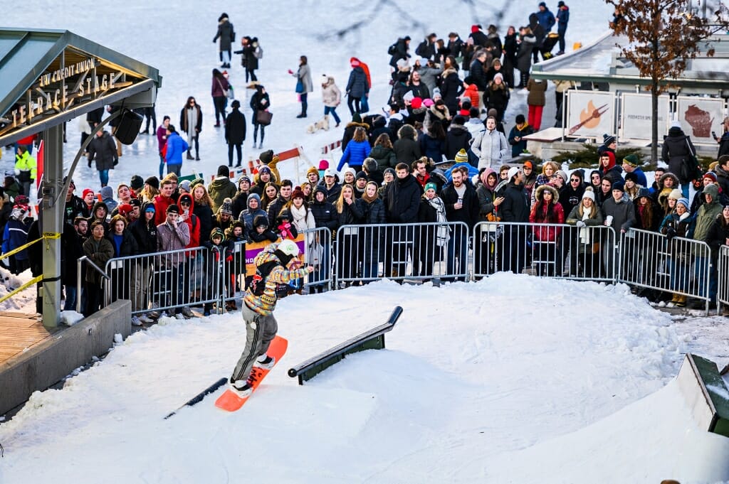 A snowboarder trudges, pulling his board.