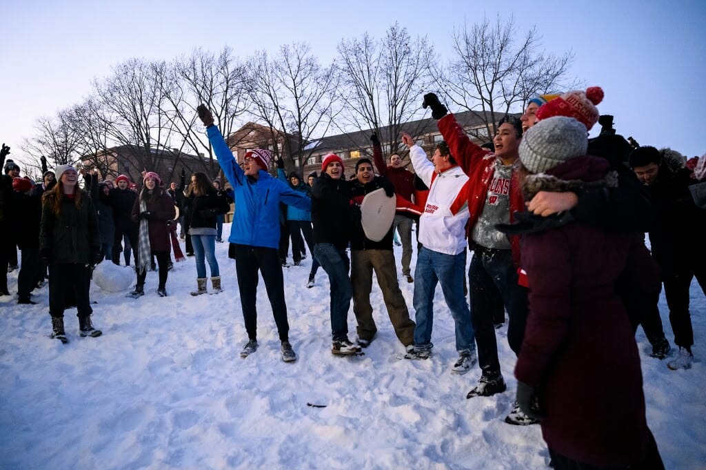 People raising their arms and cheering