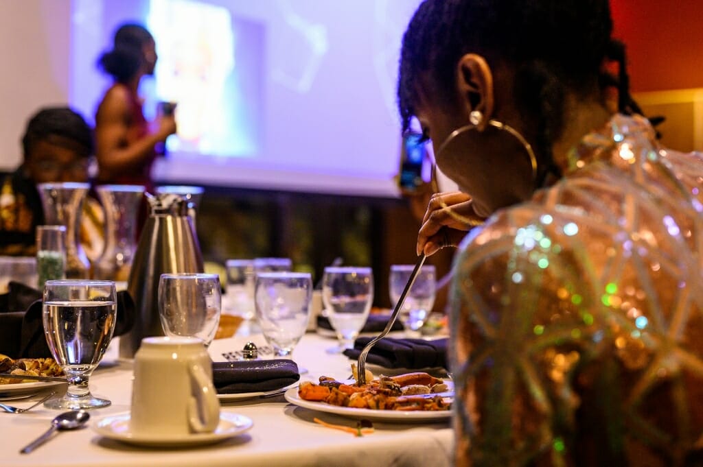 Students dine while they listen to a speaker.