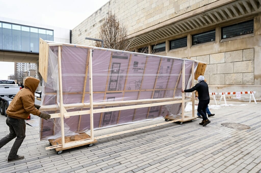 Photo: A large mural wrapped in plastic outside a museum.