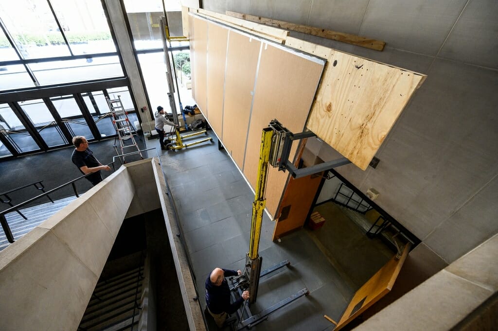 The mural, still wrapped, is lifted into position.