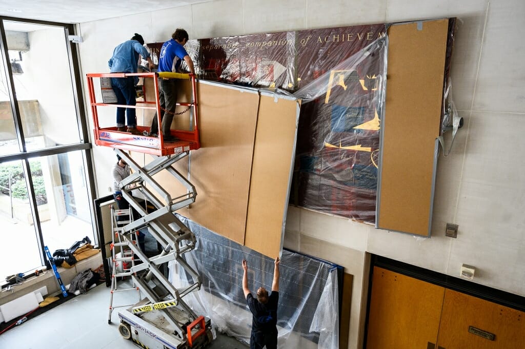 A scissors lift lifts the mural up.