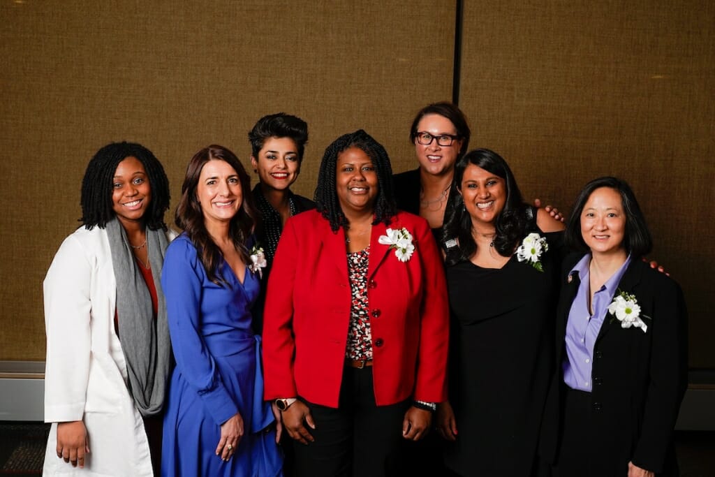 Seven women post for a photo.