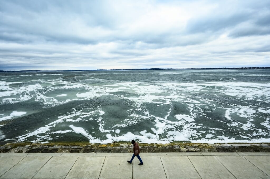 A stormy lake scene with a pedestrian.