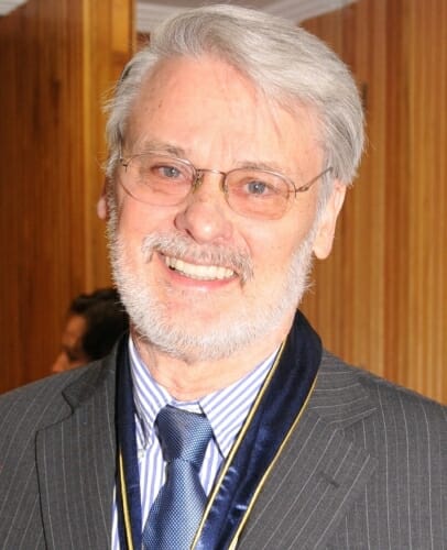 Portrait of Michael G. Moore standing in front of a wood-paneled wall