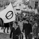 The march was organized by the Ecology Students Association. This photo was taken at the top of State Street, where a marcher carried the ecology flag. Two marchers have been identified as students Gregory James and Charley Wolfe. Photo by Bruce Fritz /