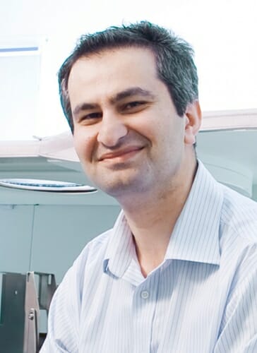 Portrait of Oguzhan Alagoz sitting in a lab