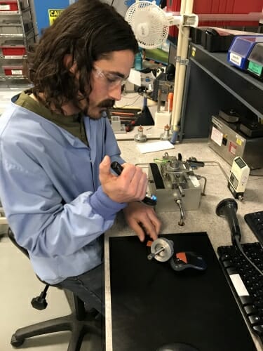 A man working with electronics at a desk.