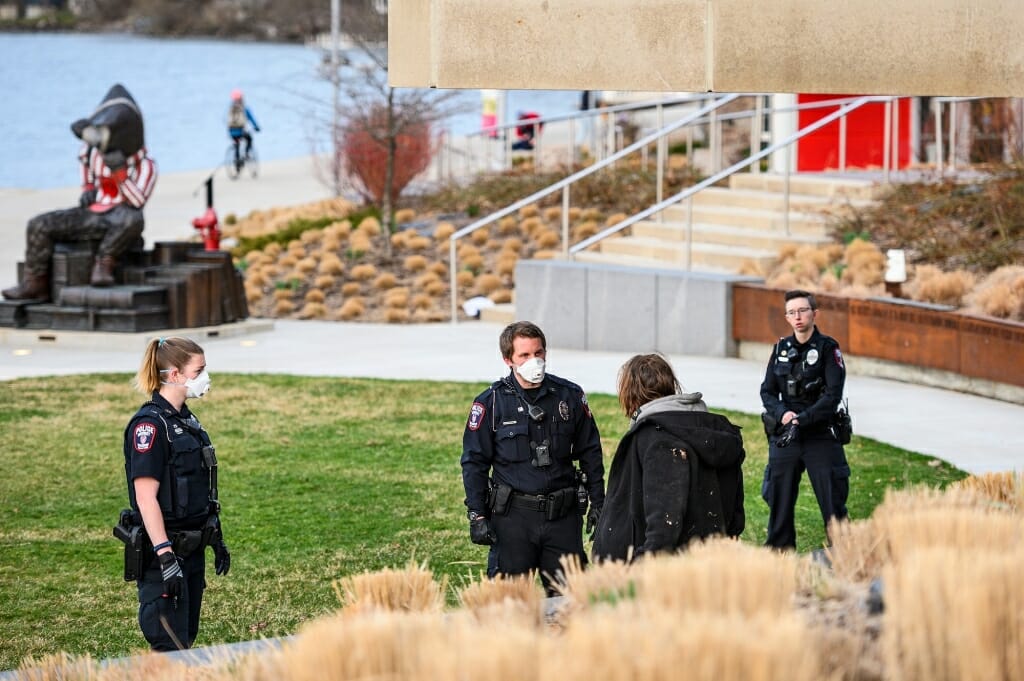 Two officers talk to a man at Alumni Park.