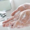 Closeup of a person's hands washing under a faucet