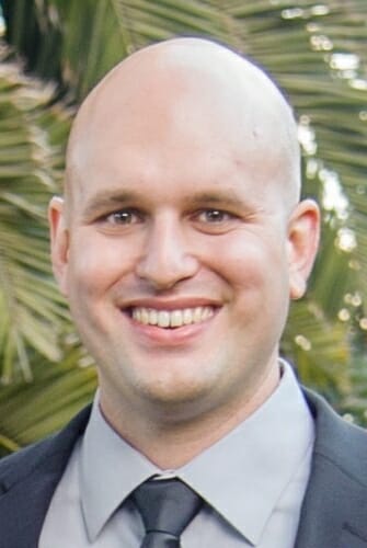 Portrait of Brian Parks standing in front of a palm tree