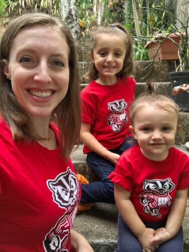 Photo of Garnier and her two young daughters all wearing Bucky Badger T-shirts