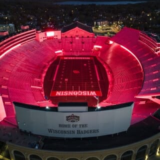 A photo of Camp Randall, lit in red, taken from above.