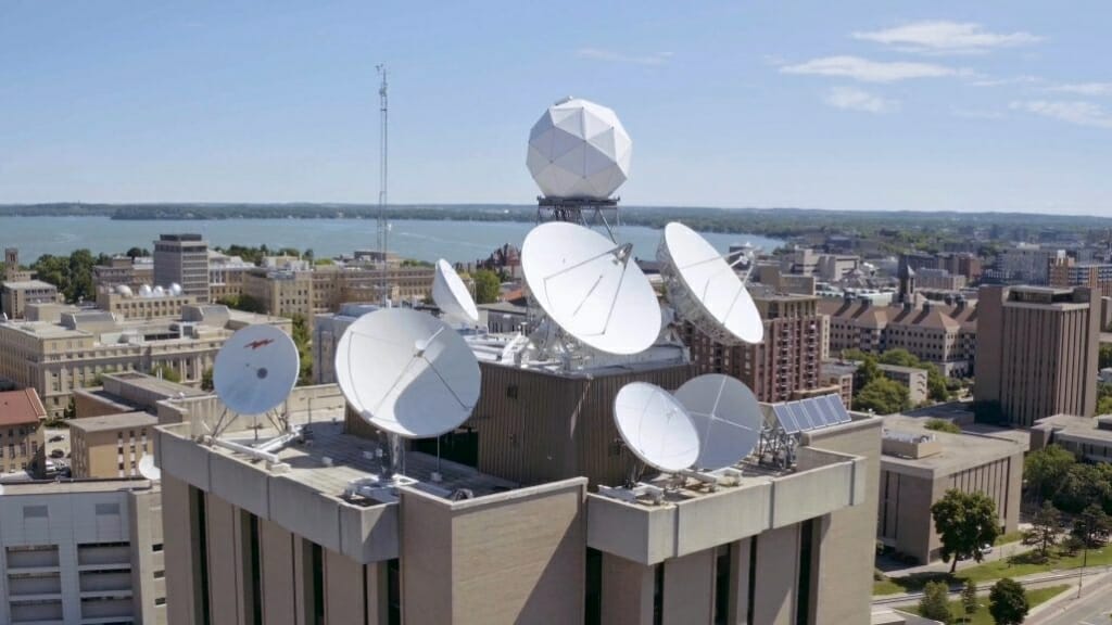 Weather radars are shown on top of a tall building.