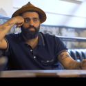 Gabriel Stulman sitting at a table speaking to interviewer