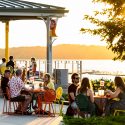 The sun sets over the lake as Terrace patrons look on.