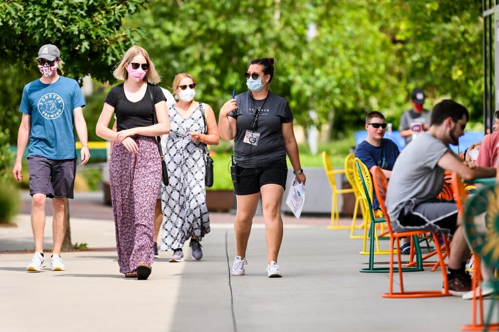 People wearing face masks are lead into the Terrace by a hostess also wearing a face mask.