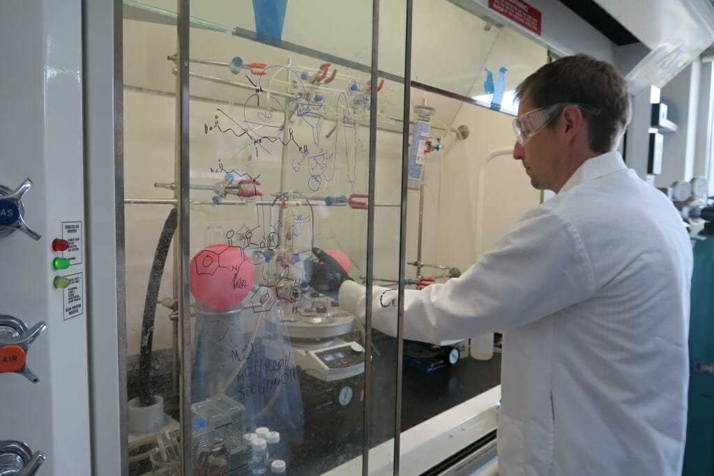 Wenthur standing at lab bench working on an experiment