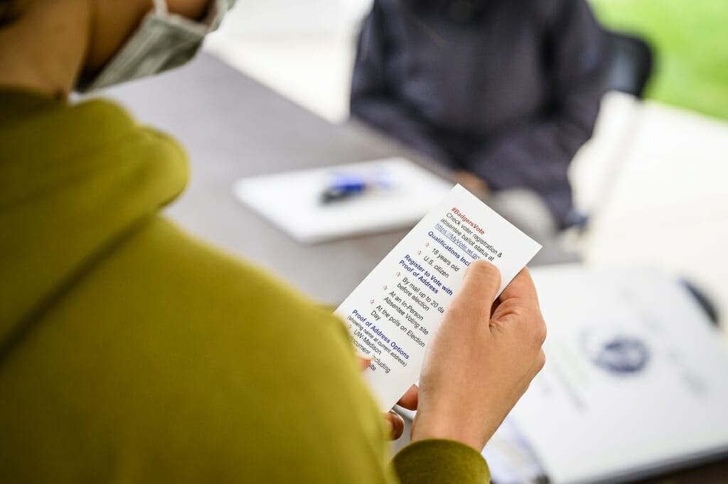 A voter reads over an information card with details on voting.