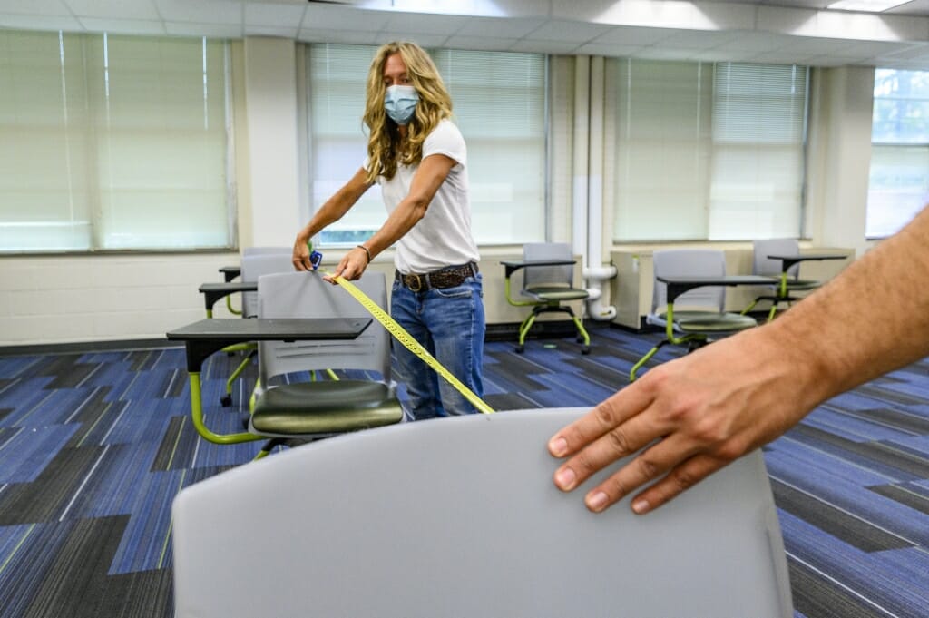 Larsh (left) and Tom Wise (right) measure a classroom that is being reconfigured.